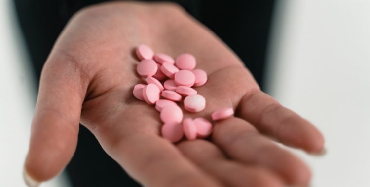 A person with a handful of meds