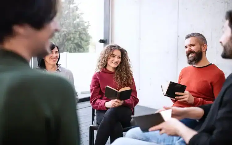 men and women sitting in circle during group therapy