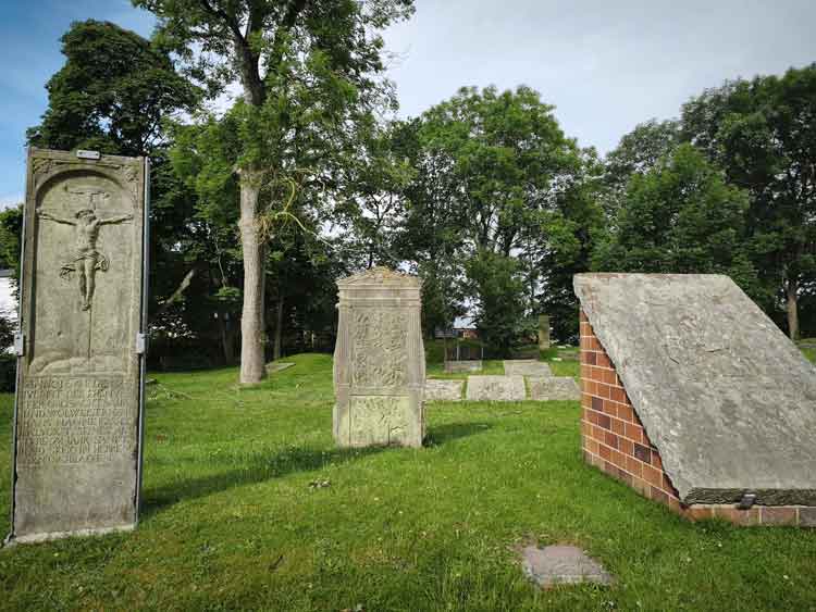 Ein Blick auf die Steine des Geschlechterfriedhofs. Die Steine sind verziert und tragen Schriften.