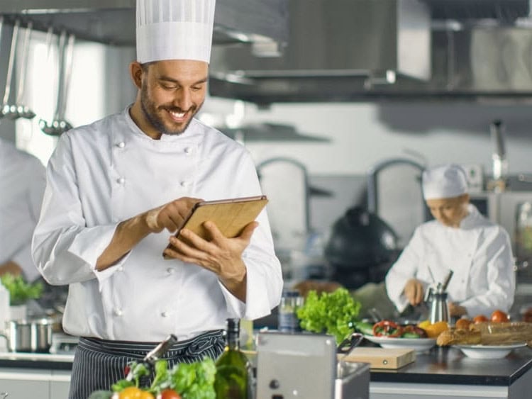 K&uuml;chenchef verwendet Tablet-Computer f&uuml;r necta w&auml;hrend der Arbeit