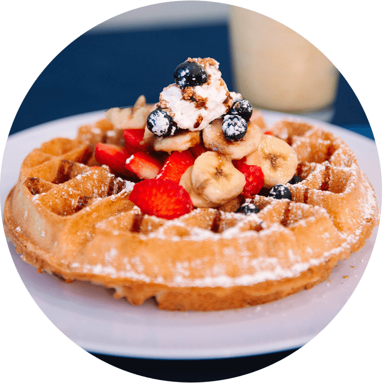 Waffle topped with strawberries, bananas, blueberries, and whipped cream at Sweet Spot Cafe in Bellaire, Texas