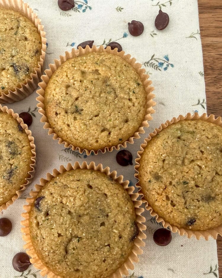 Close-up of healthy zucchini muffins with chocolate chips scattered on a floral kitchen towel