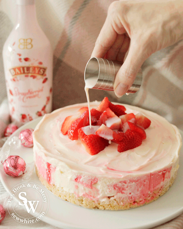 Baileys Strawberries and cream being poured over the no bake cheesecake.