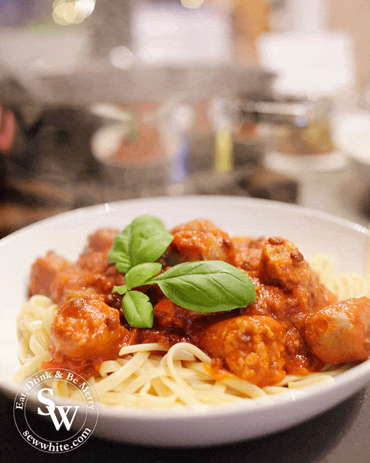 Sausage and lentil pasta topped with a fresh basil leaf