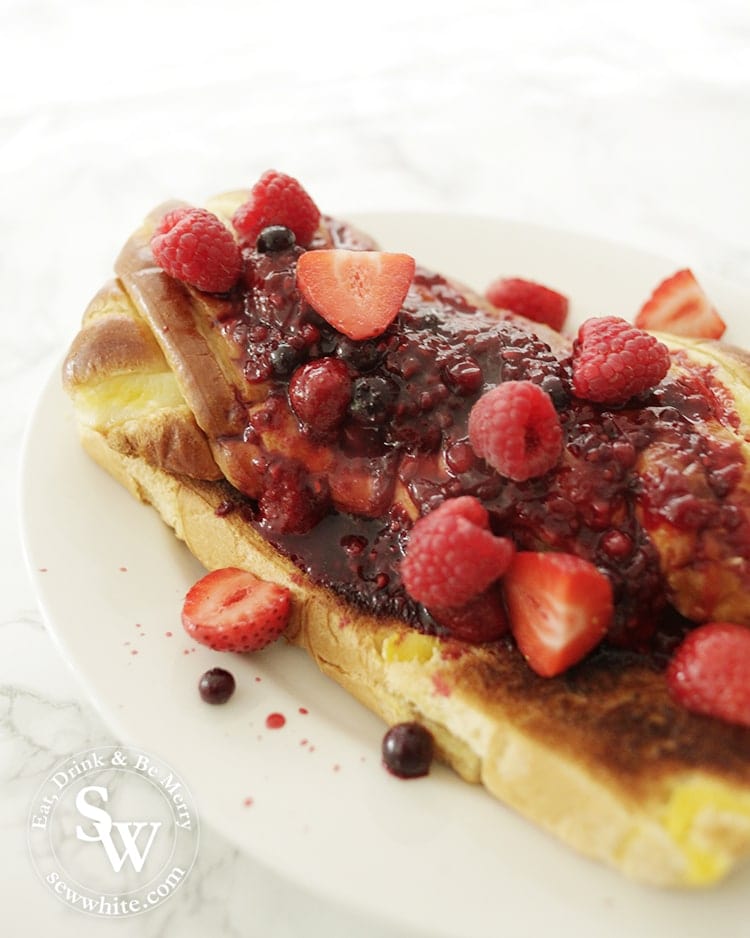 Brioche Bread Pudding covered in hot fruit compote and fresh berries