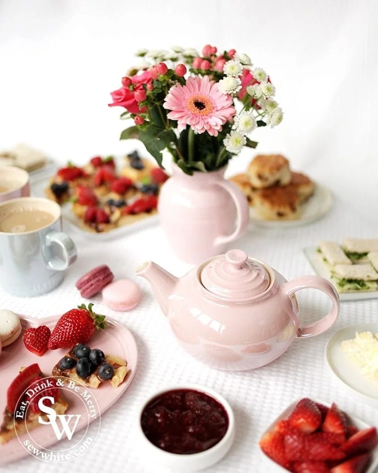 Afternoon tea served with the chiffon pink glace teapot served with lots of freshly baked treats and fresh fruit.