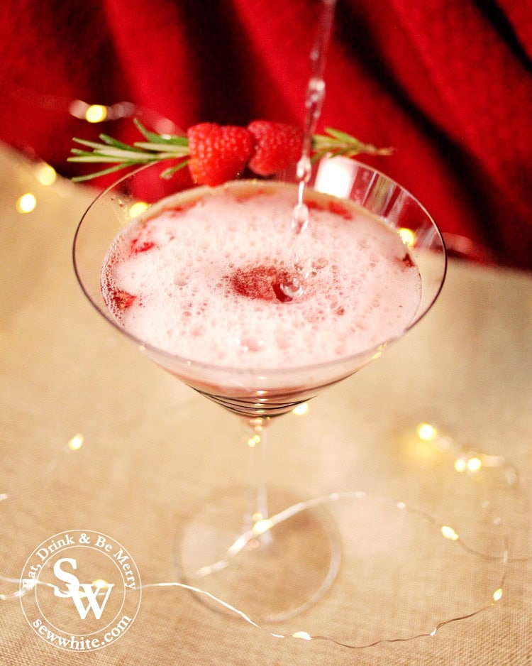 Christmas Rum and Raspberry Cocktail cocktail being made on a red and Hessian backdrop 