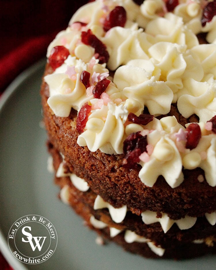 A close up of the sprinkles on the swirly buttercream on the white chocolate and cranberry cake