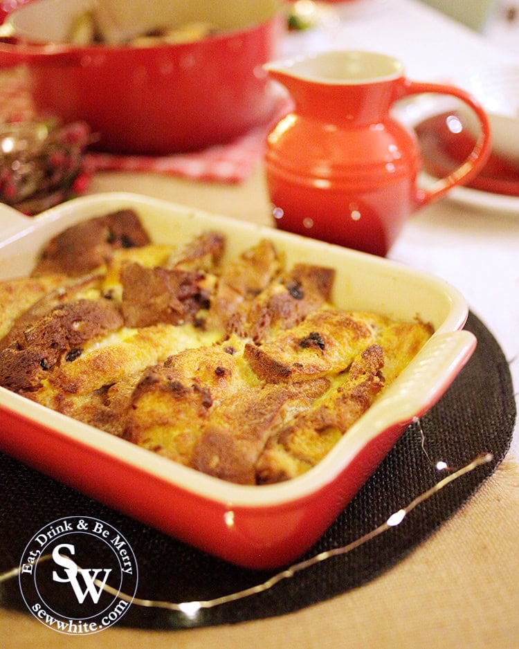 Christmas panettone bread and butter pudding in the Le Creuset red Stoneware Heritage rectangle dish on the Christmas table with fairy lights.