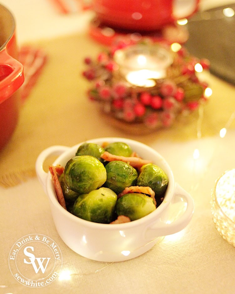 Brussels Sprouts cooked with bacon and salt in the Le Creuset petite casserole on the Christmas table surrounded by candles.