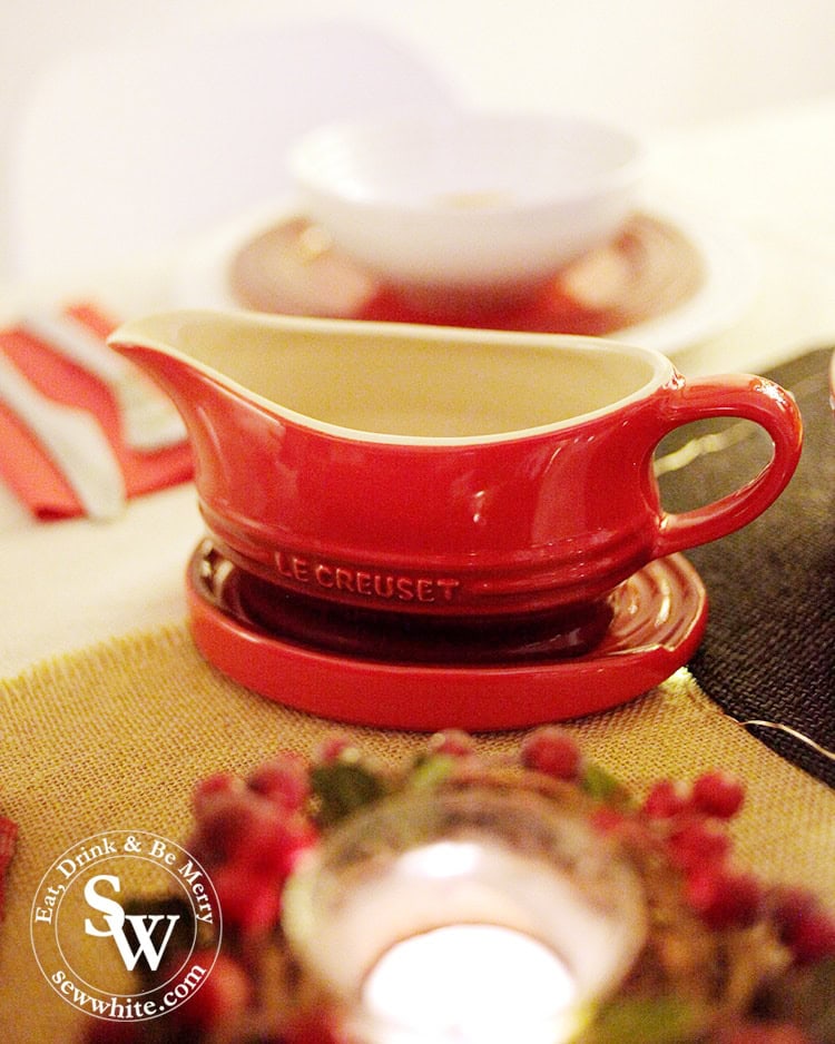 Gravy boat on the oval spoon rest in Christmas red from the Le Creuset collection