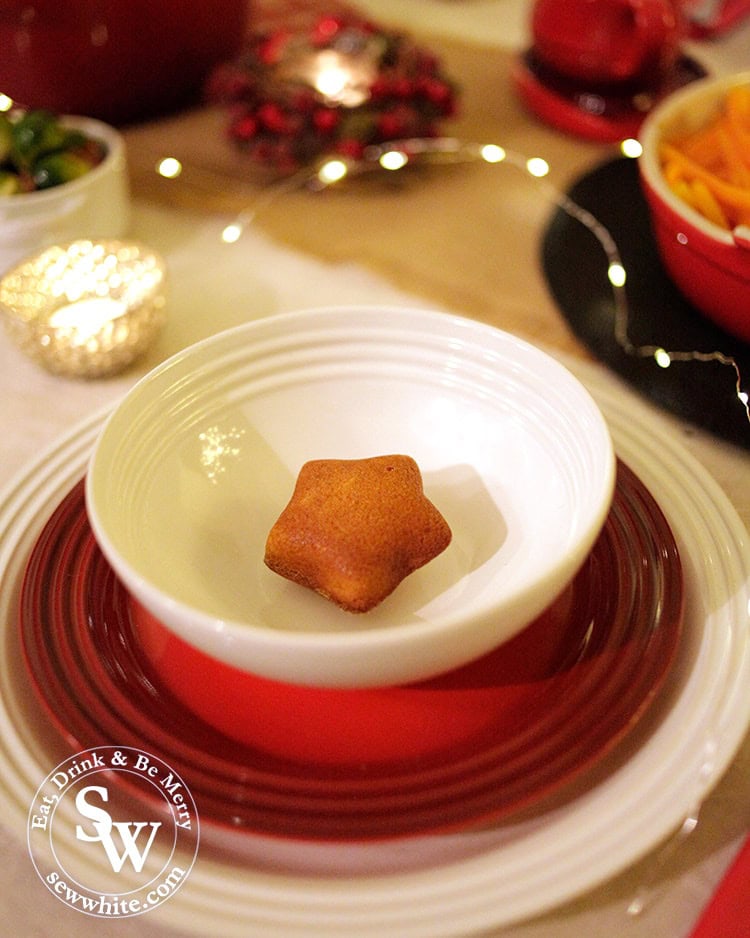 Christmas place setting with Le Creuset red and white plates.