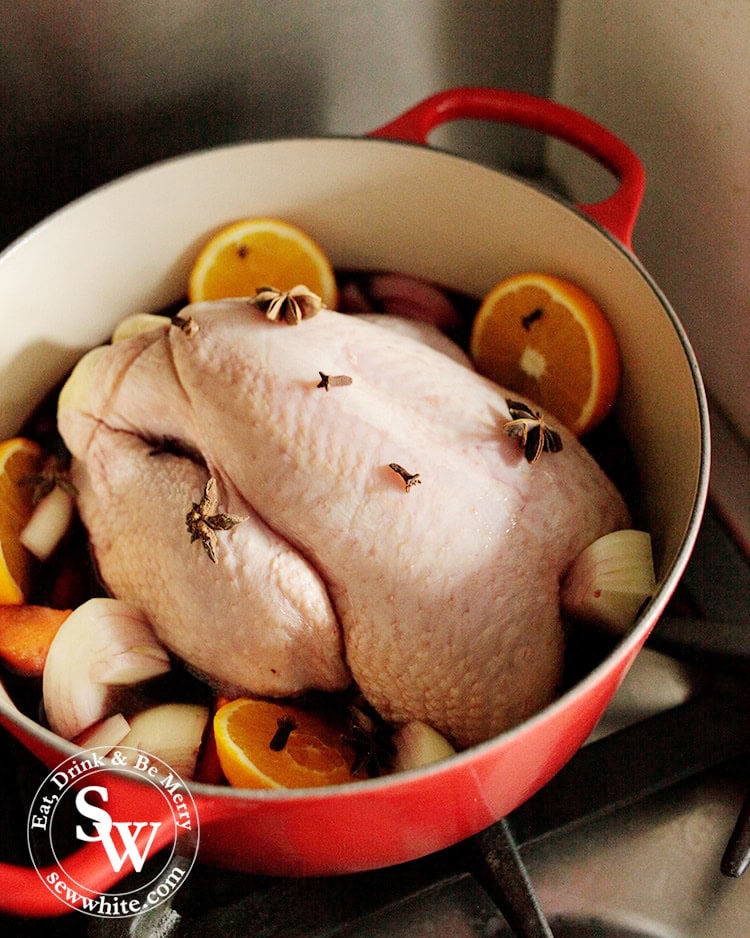 Christmas One Pot Chicken cooked with red wine and oranges cooking on the hob