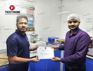 Testron technician handing over training certificate for TT-NP1 Bursting Strength Tester to Romana Water Industries team