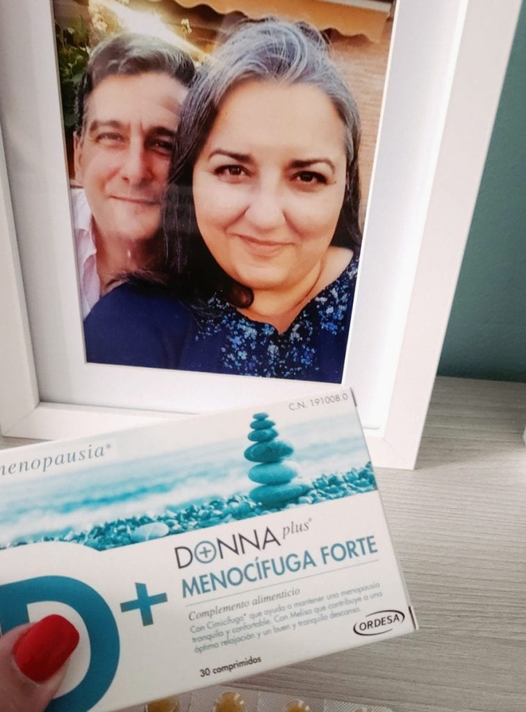 Caja de Donnaplus Menocifuga Forte apoyada en un marco con la foto de una pareja