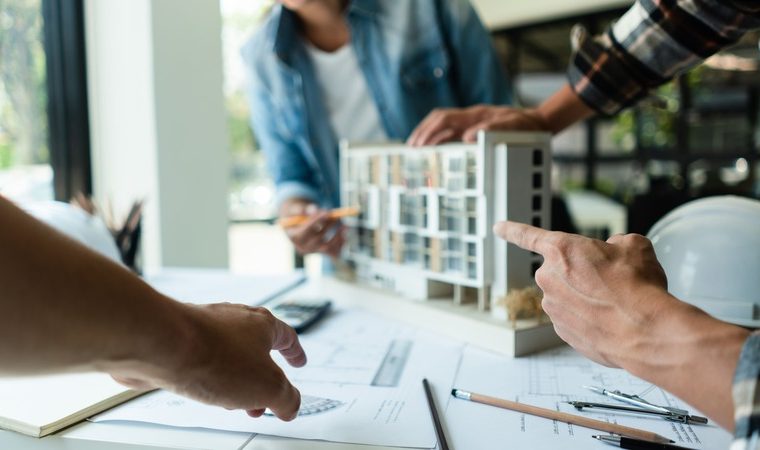 sopraelevazione condominiale, uomini discutono lavori condominiali con modellino