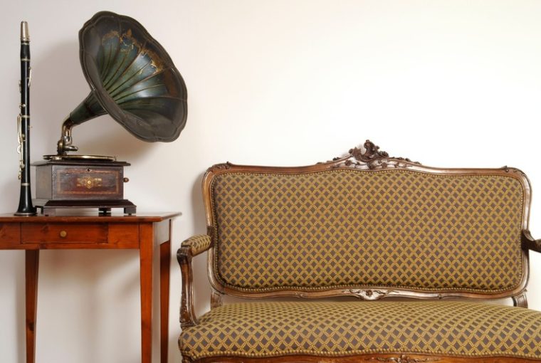 mobili vintage; piccolo divano vintage a due posti, piccolo mobiletto rosso e giradischi con grammofono
