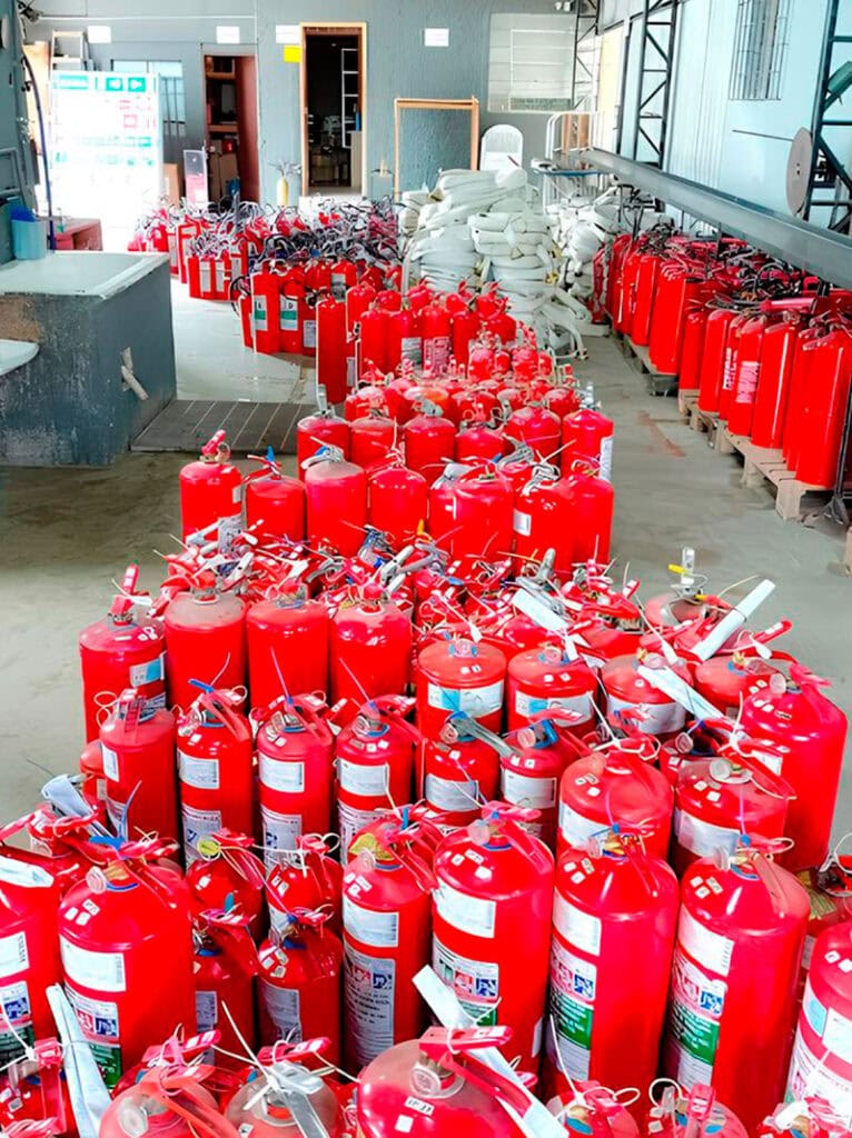 Vários extintores vermelhos no chão.