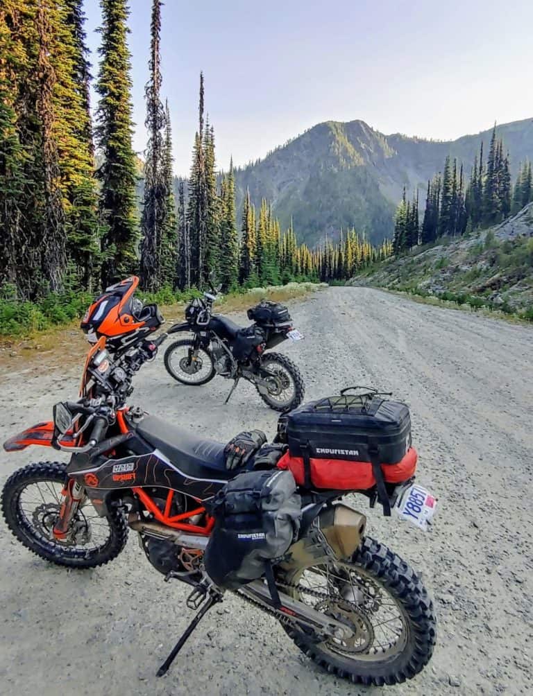@proto__koot and @missvelocity's motorcycles on the road at the top of Grey Creek Pass