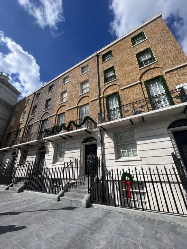 Charming brick apartment building with festive holiday decorations in a vibrant city neighborhood.