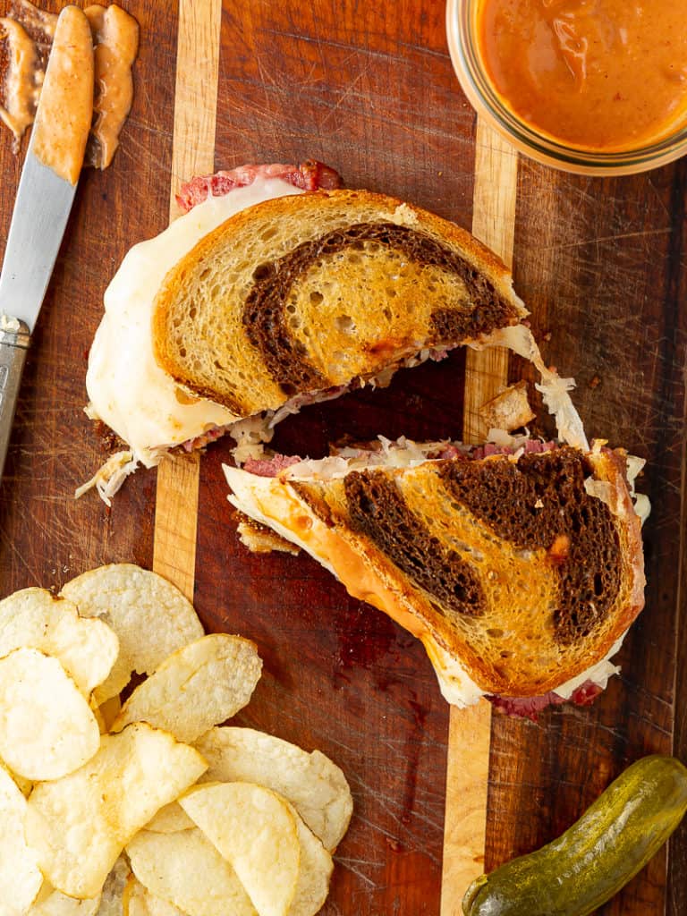 reuben sandwich with chips and pickle