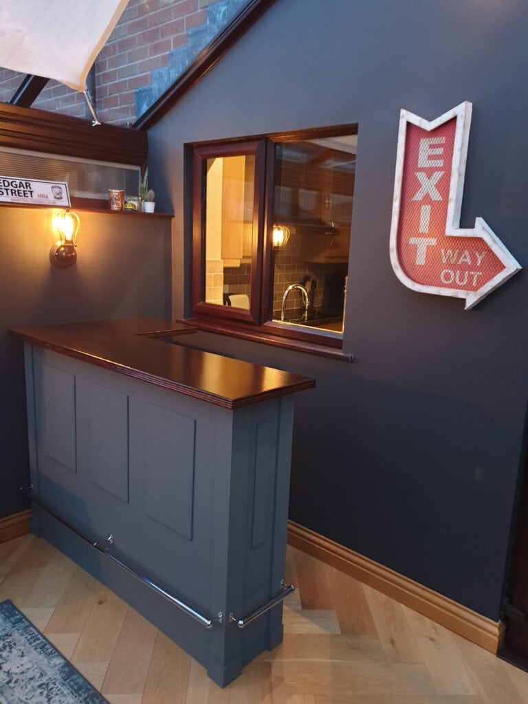 The Nelson home bar in navy blue against a navy blue wall and with a dark brown top