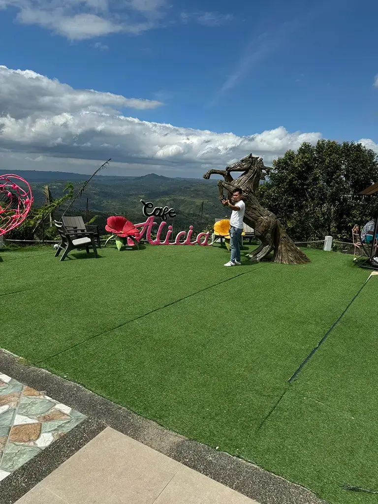 Another picture of the Cafe Alicia sign on the patio with a gorgeous view in the background.