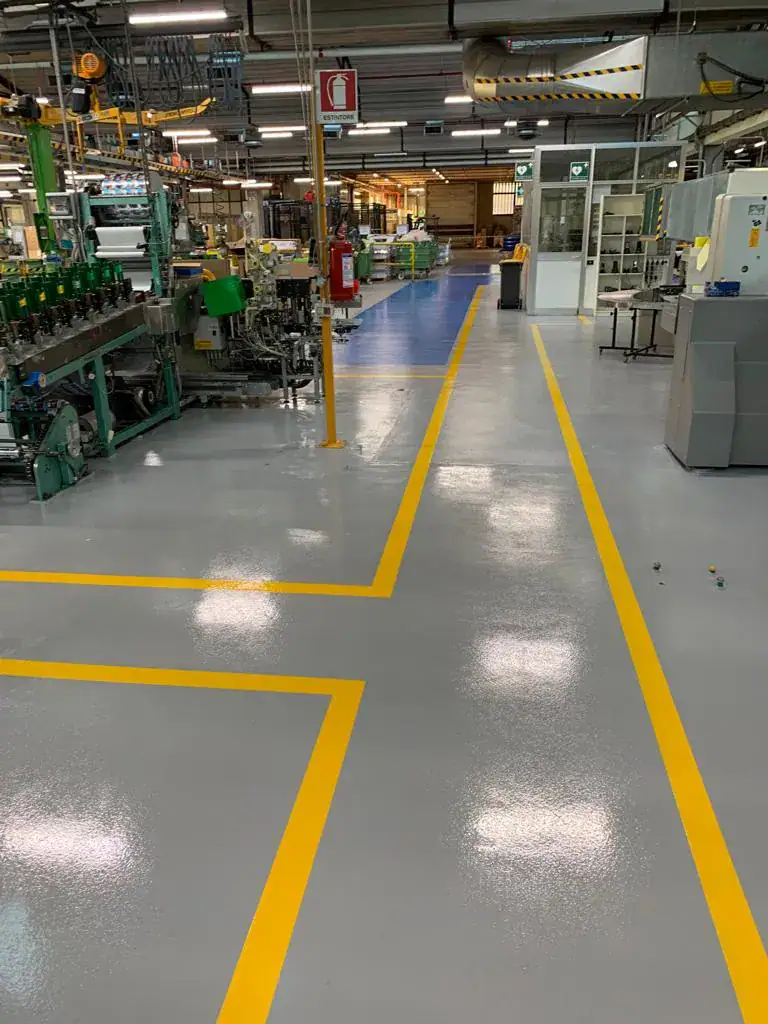 Vista corridoio con pavimento in resina epossidica e segnaletica orizzontale – industria tipografica