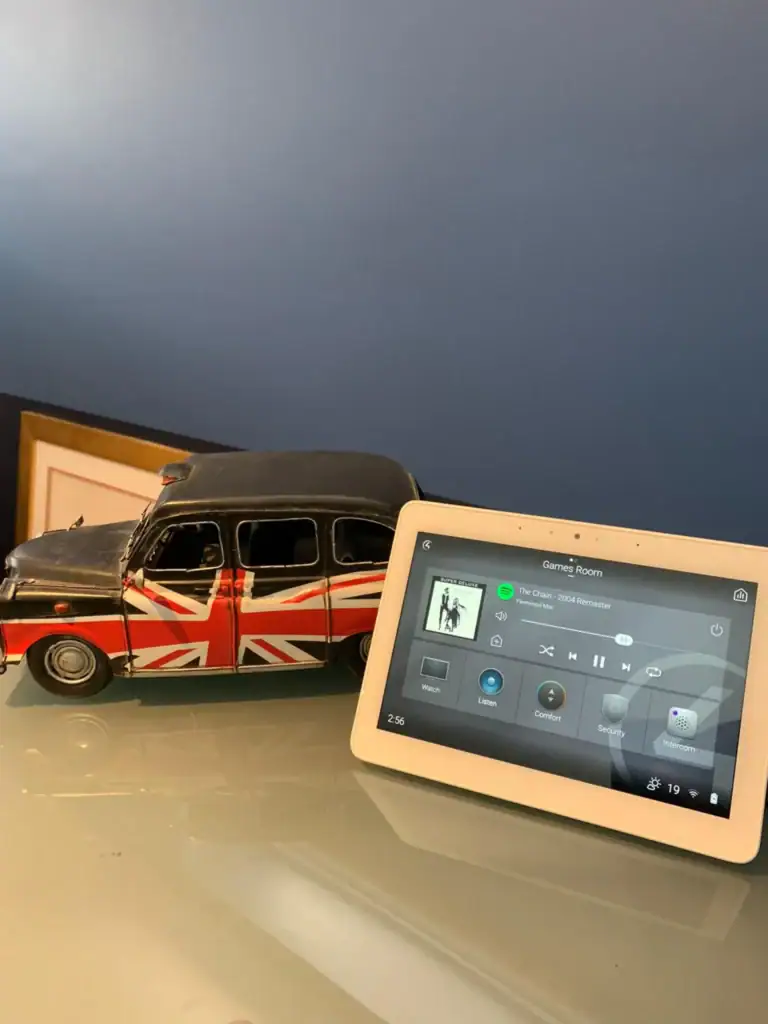 Control4 touchscreen beside a model London taxi