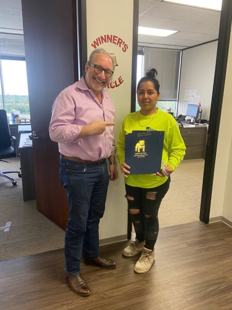 Victorious client celebrates legal win with The Miller Law Firm team.