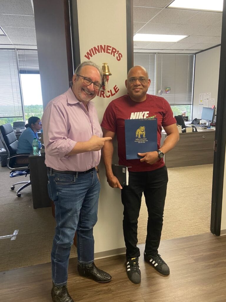 Client proudly rings the bell after a successful claim with The Texas Bulldog.