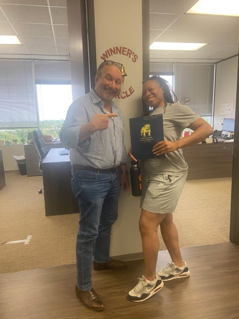 Client celebrating successful case outcome with The Texas Bulldog team in Houston.