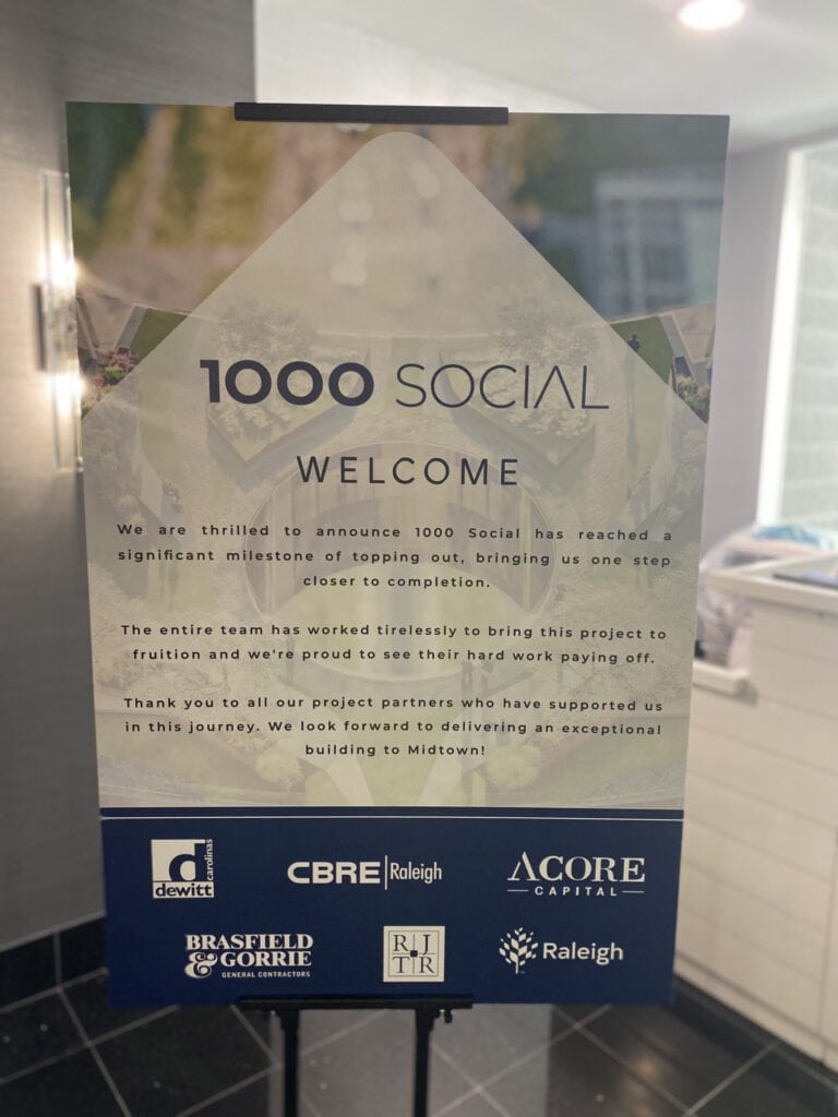 A lobby sign welcomes guest to the 1000 Social Topping Out Party, celebrating a construction milestone on the Raleigh office and event space