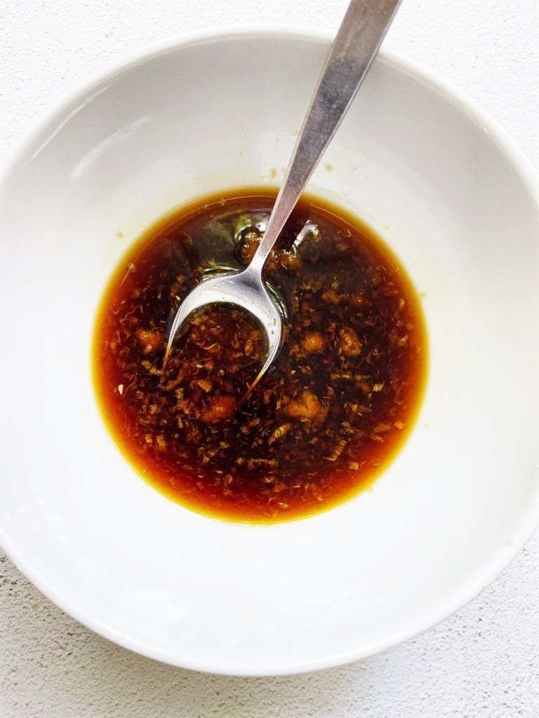 Top down image of a small white bowl containing teriyaki sauce.