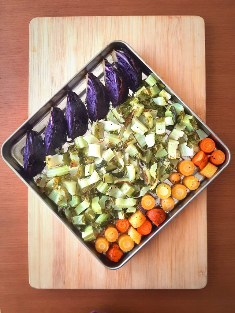 Top view of roasted cauliflower greens with carrots and purple cabbage