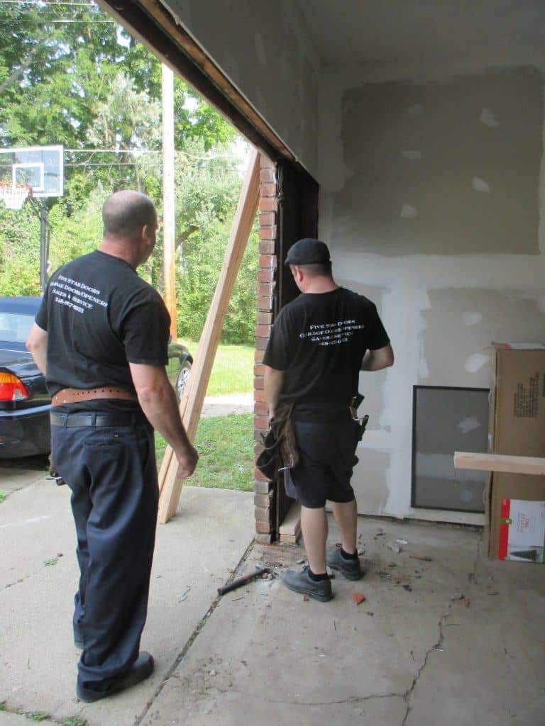 alt="Shane and Andrew working on a garage door in South Lyon, Michigan"