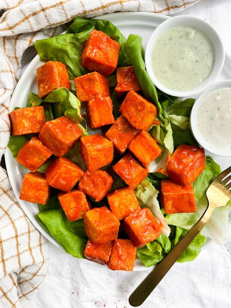 top shot of tofu tossed in buffalo sauce next to ranch