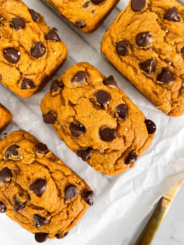 overhead shot of vegan pumpkin bread next to a gold knife