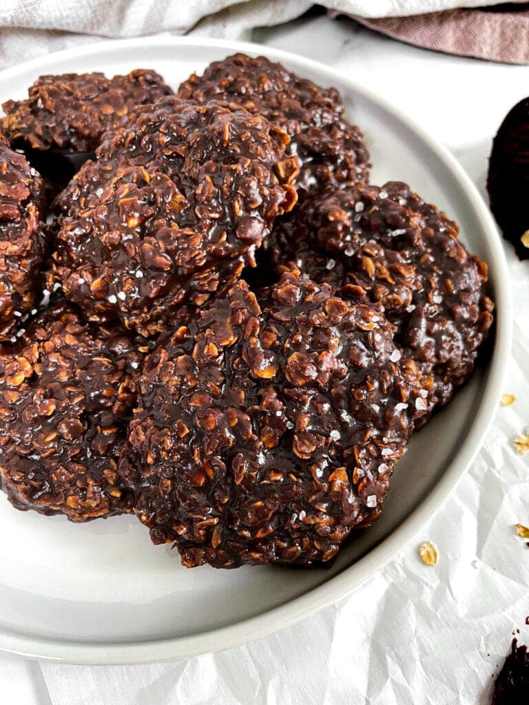 no bake cookies on a white plate with oats sprinkled around
