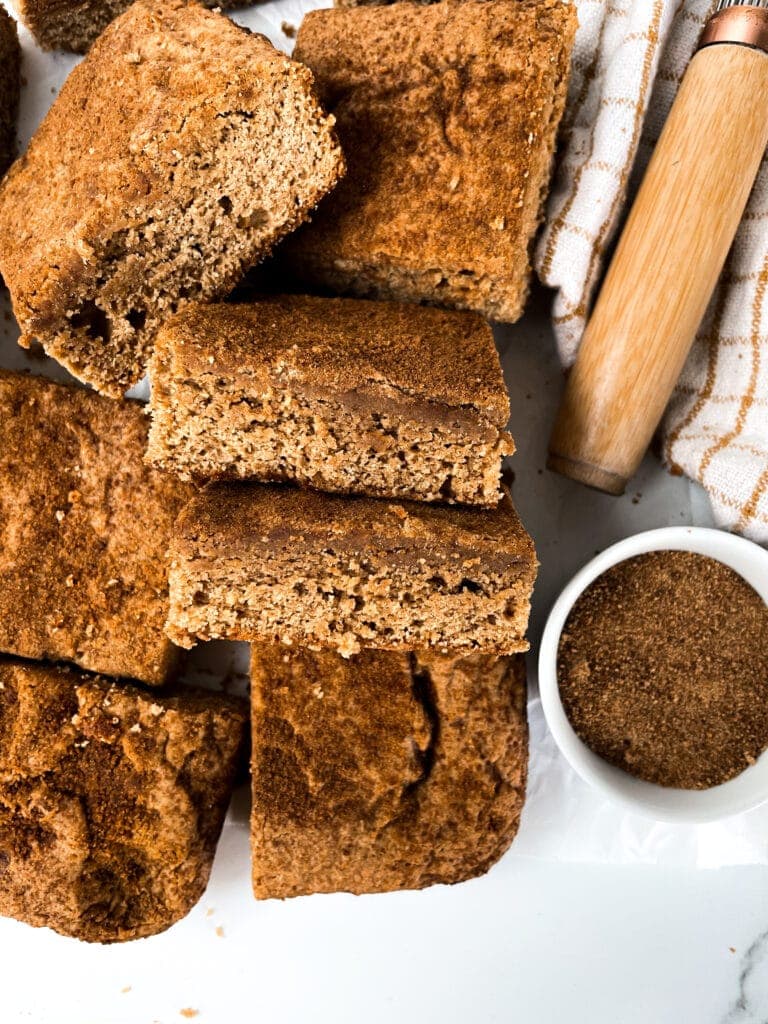 top view of snickerdoodle bars next to a bowl of cinnamon