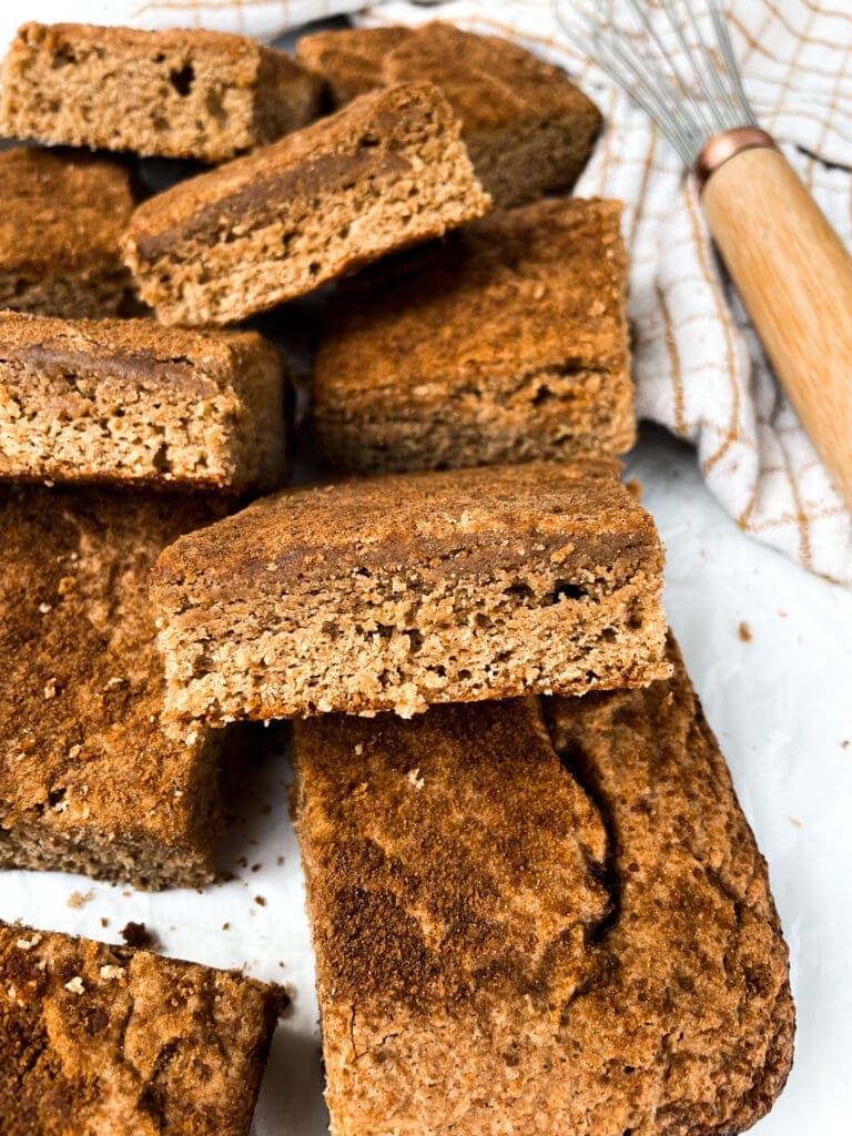 snickerdoodle bars next to a towel and a whisk