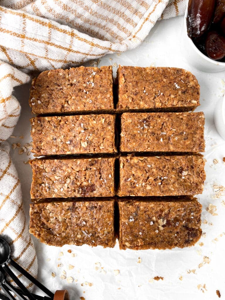 overhead shot of sliced oatmeal date bars next to a kitchen town