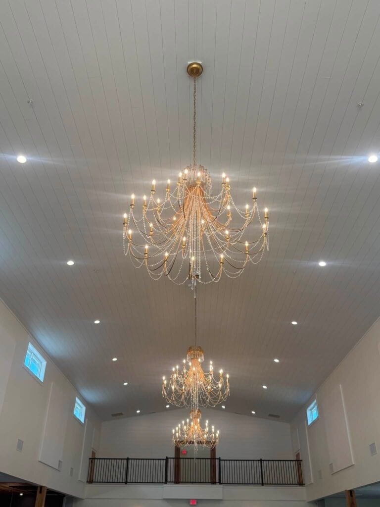 Crystal chandeliers hanging from the reception hall ceiling at Romaine Valley Weddings & Events in Fenton, MO