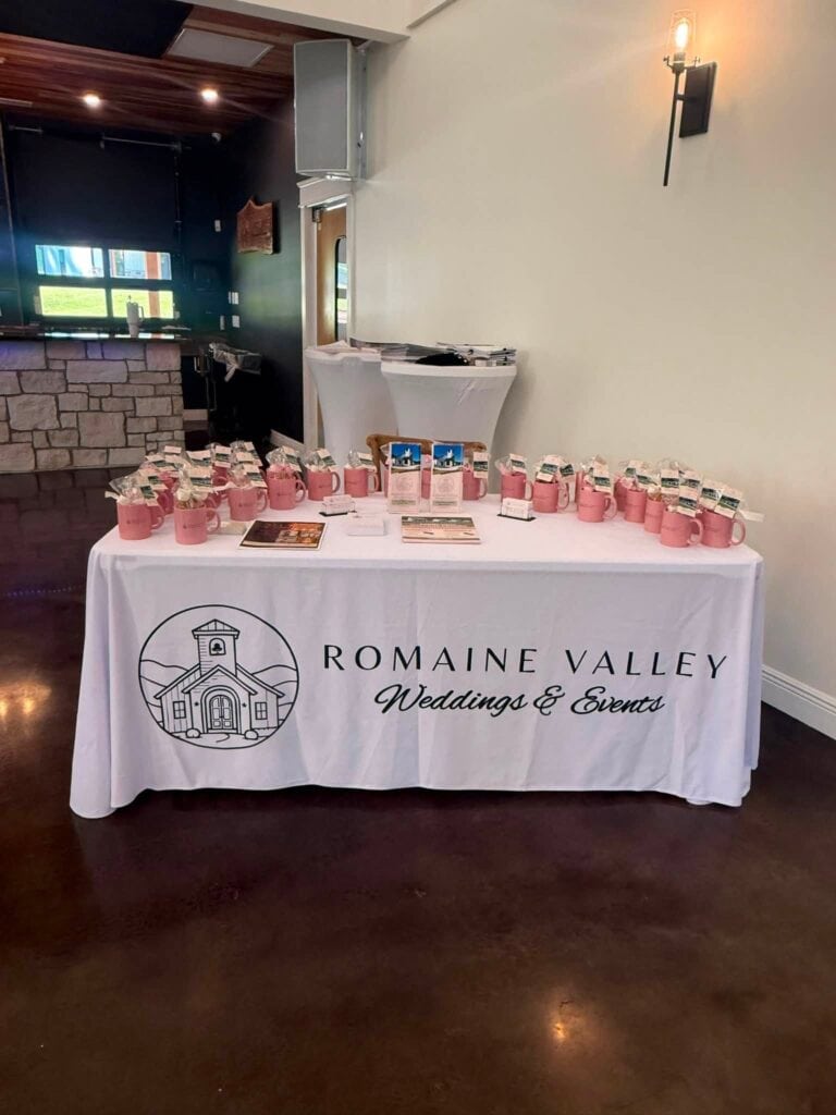 Romaine Valley welcome table with pink linens at the Open House in Fenton, MO