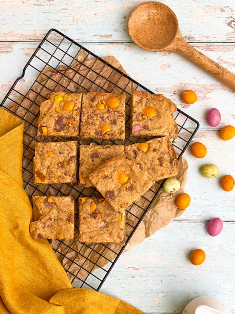 Super Easy Mini Eggs Blondies - A 30-minute Easter Traybake 1 mini eggs blondies on a cookie rack, mini eggs on the side