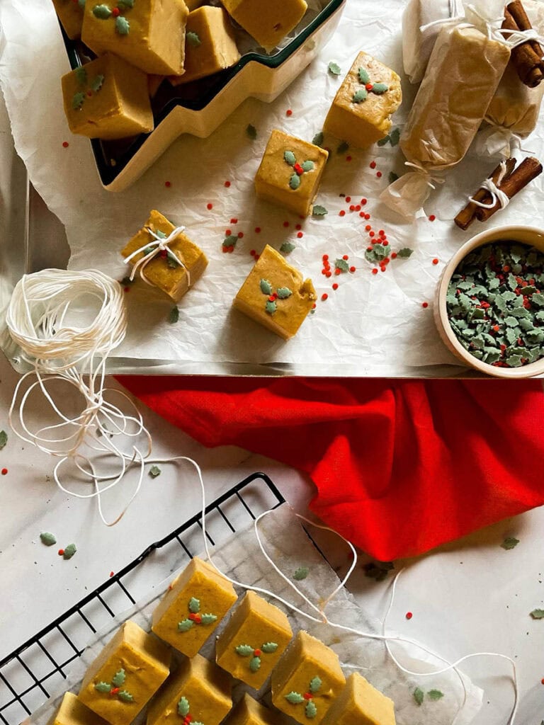 easy no bake peanut butter fudge in a christmas tree dish over on a silver baking tray with christmas sprinkles
