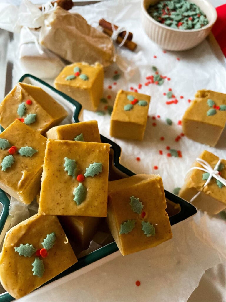 easy no bake peanut butter fudge in a christmas tree dish over on a silver baking tray with christmas sprinkles