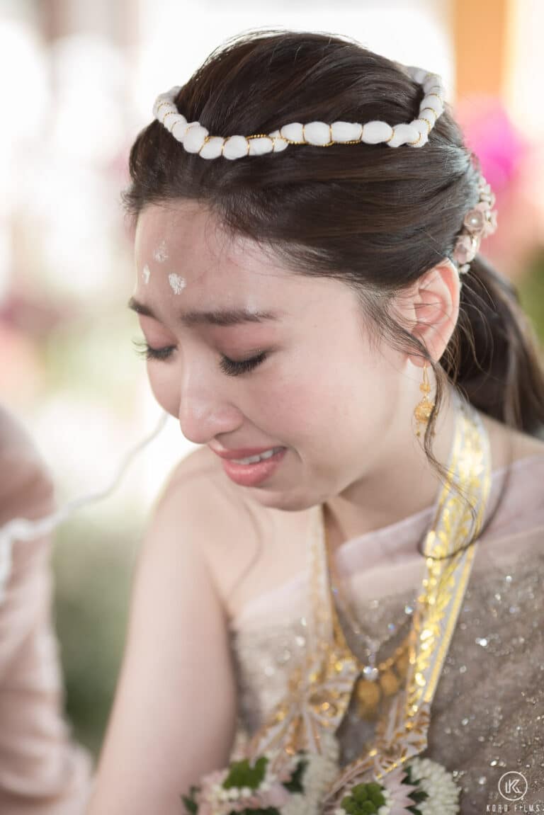 The bride in tears as her family pour water over her hands at the Rod Nam Sang water blessing at Dusit Thani Hua Hin