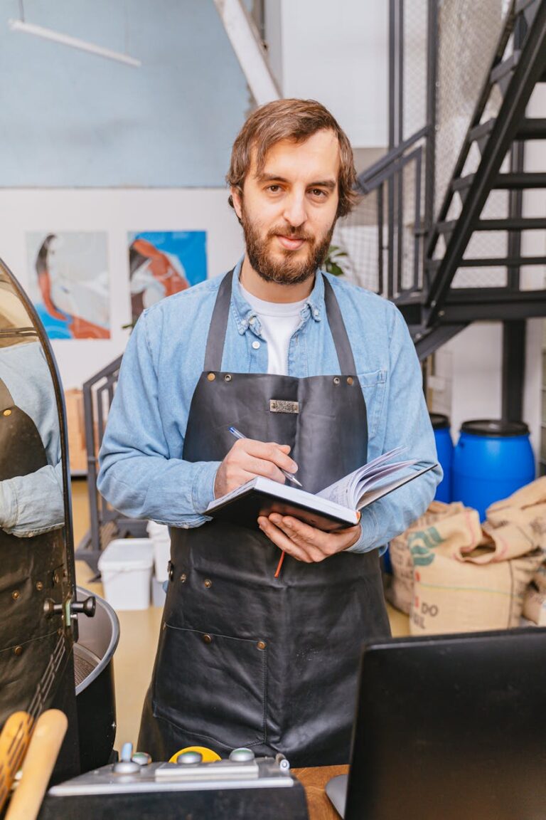 person wearing black apron holding notebook and a pen