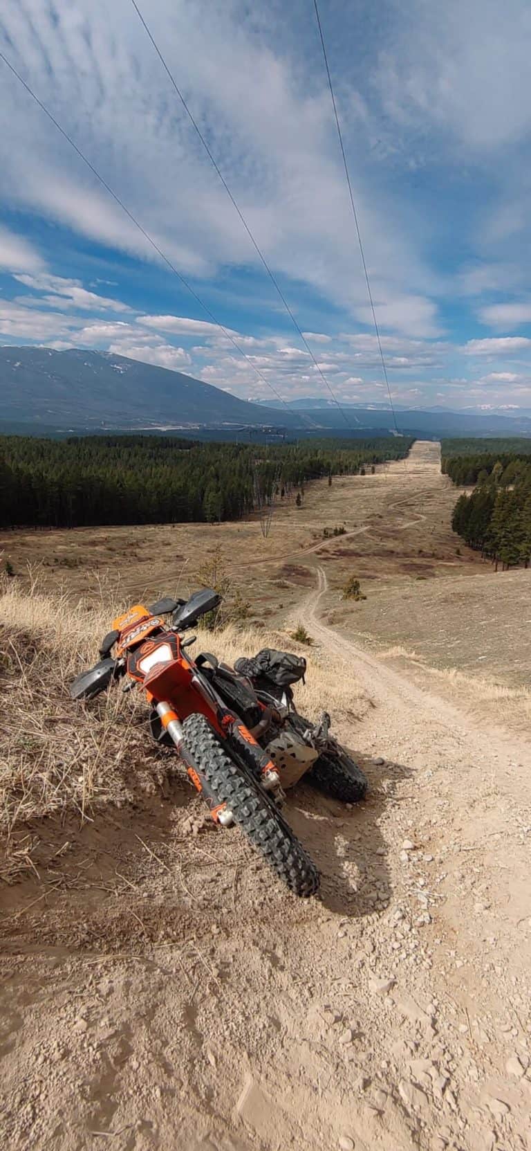 motorcycle leaned over on steep trail